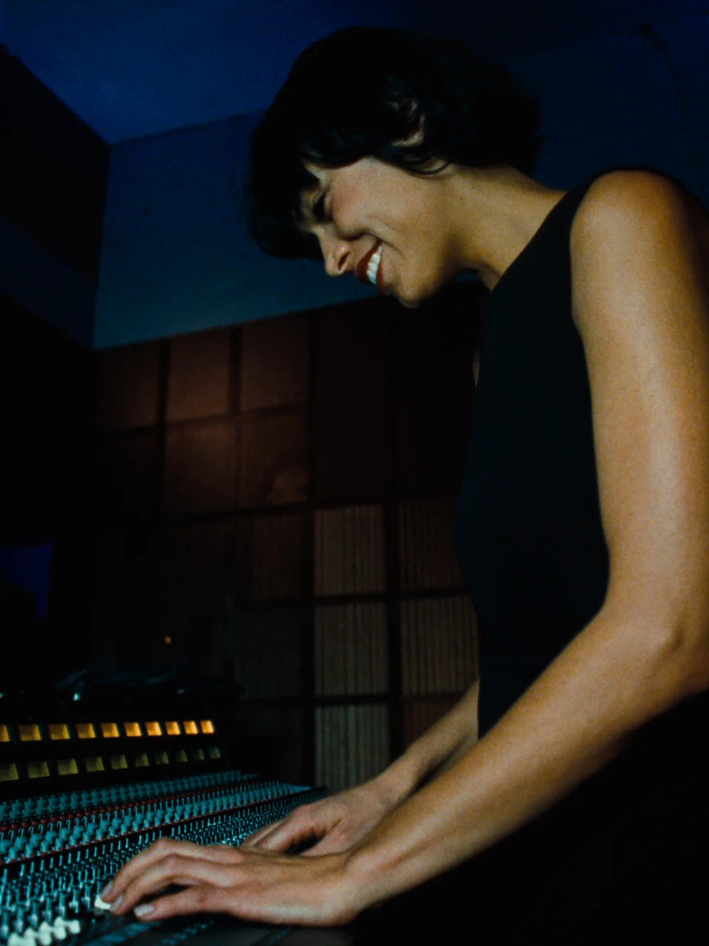 Producer at a mixing desk in a softly lit studio